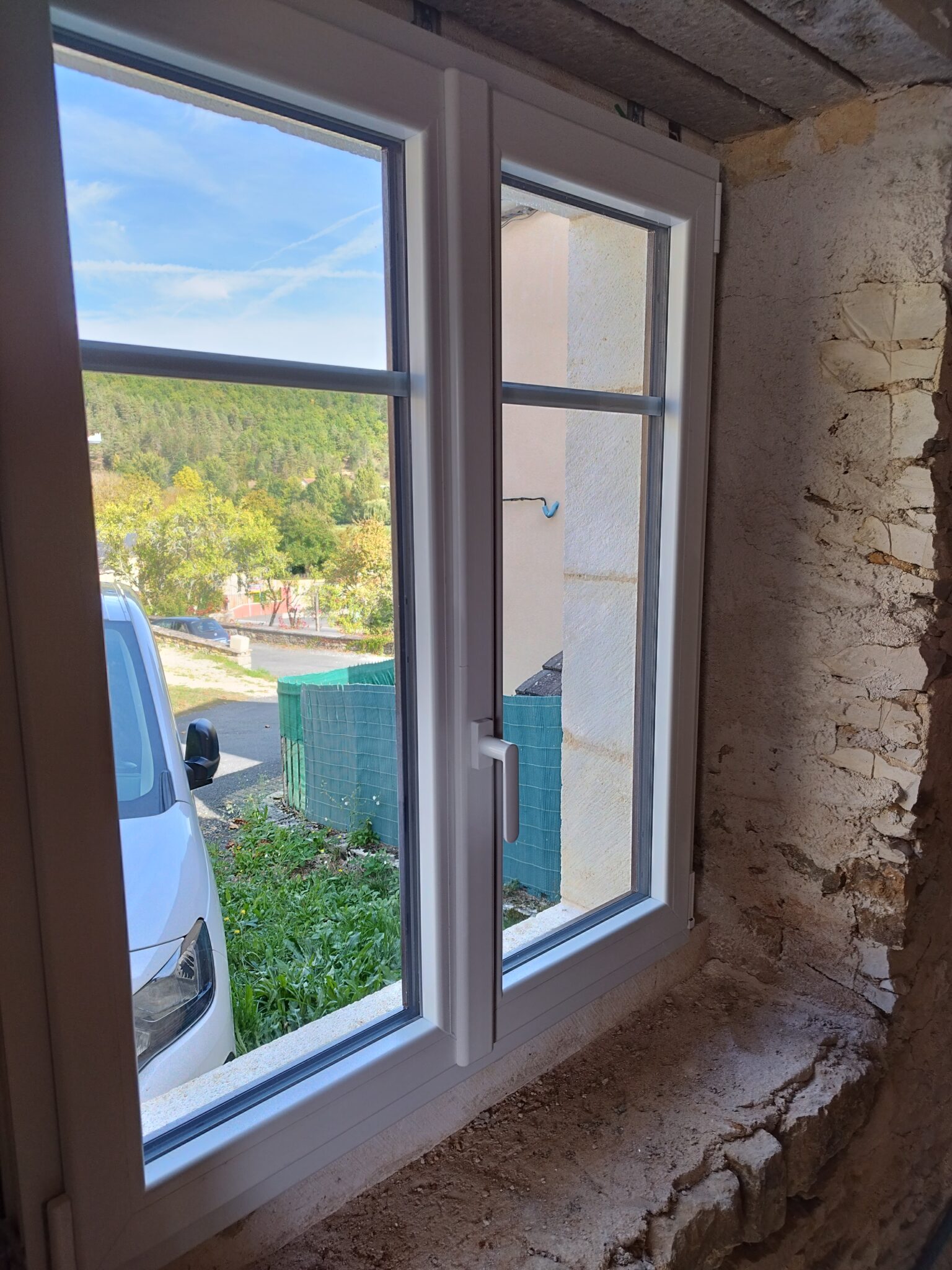 Installation d'une fenêtre double vitrage blanche moderne, assurant une meilleure isolation thermique.